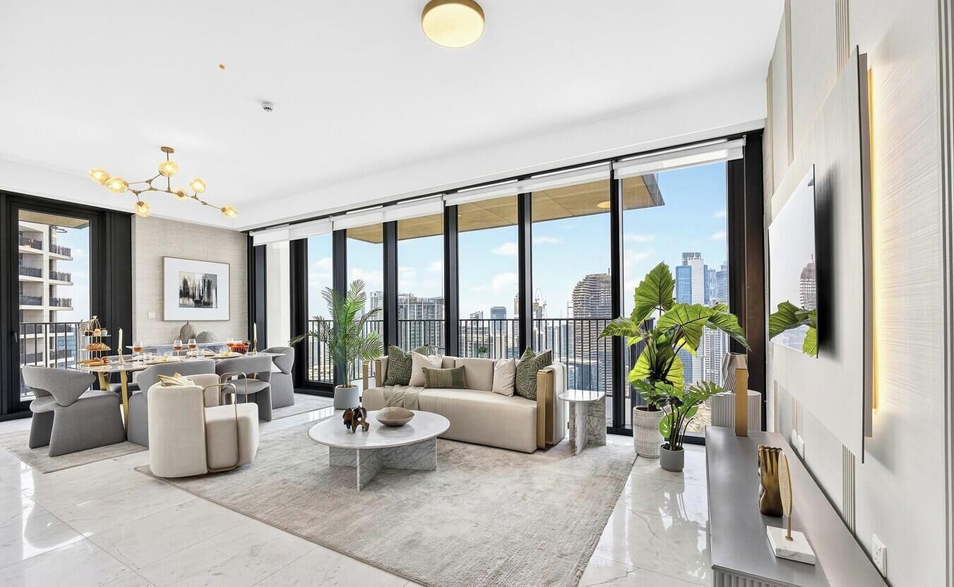 Un salon spacieux avec un canapé, une table basse et de grandes fenêtres offrant une vue sur la ville.
