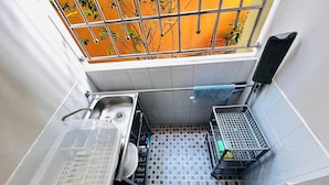 A small kitchen with a sink, a drying rack, and a window with a view of trees. - Room-105 Budget Room, Wifi&utilities Ban (Bangkok)