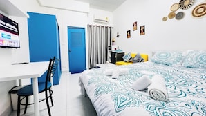 A hotel room with a bed, a desk, a chair, a television, and a door. - Room-105 Budget Room, Wifi&utilities Ban (Bangkok)