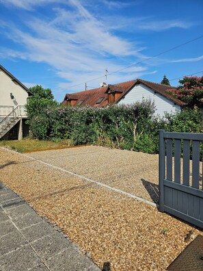 A residential property with a gravel driveway, a wooden fence, and a white house with a red roof. - Entire Rental: La Caze (Saint-Gervais-la-Forêt)