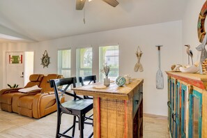 A modern living room with a sofa, chairs, a wooden table, and a colorful cabinet. - On Preserved Land w/ Pool & Trails! Cape Coral Gem (Cape Coral)