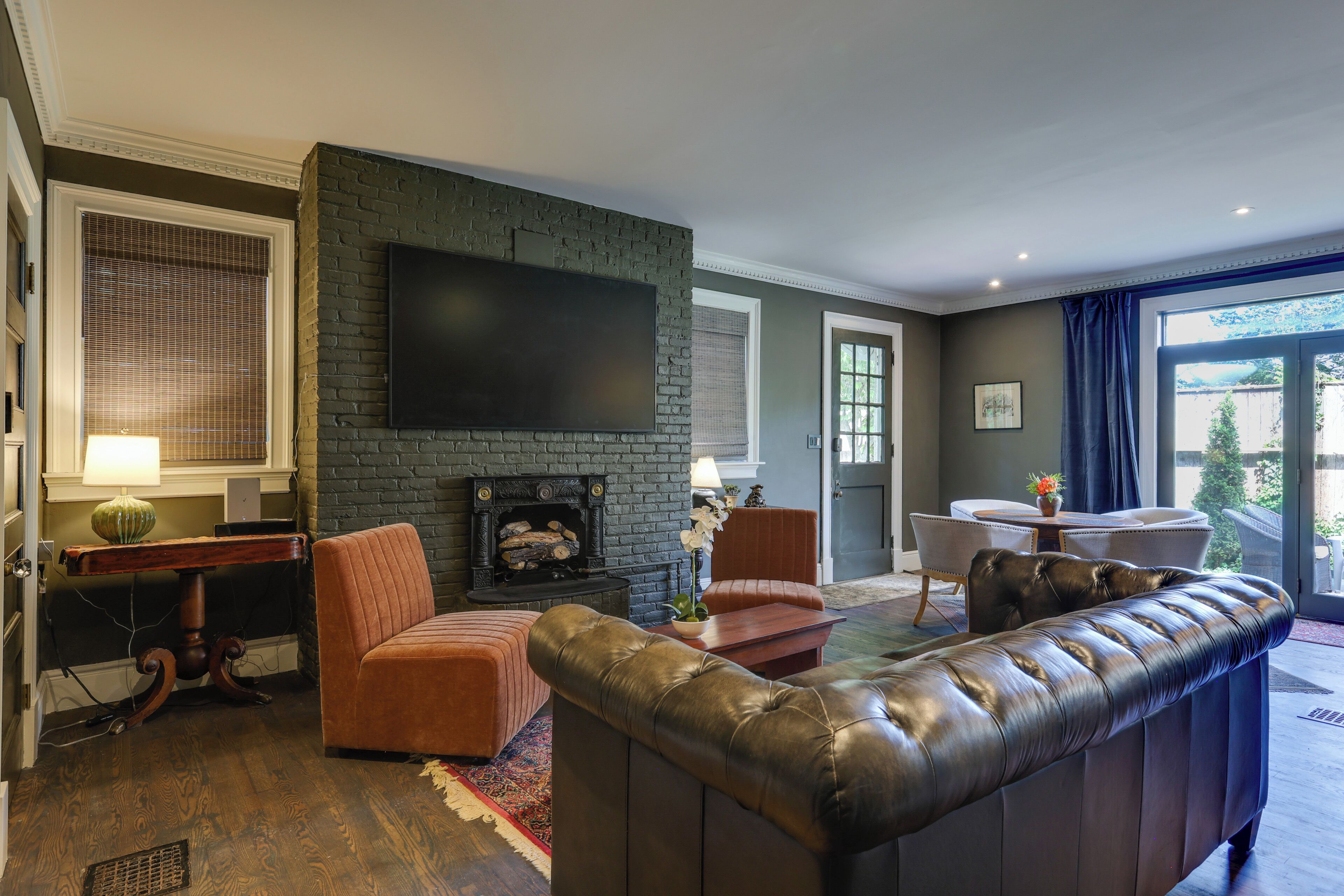 A living room with a fireplace, leather sofa, and a flat-screen TV.
