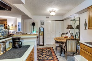 A kitchen with a coffee maker, a dining table with chairs, and a mirror. - Walk to Parks & Dining! Lakewood Condo w/ Balcony (Lakewood)