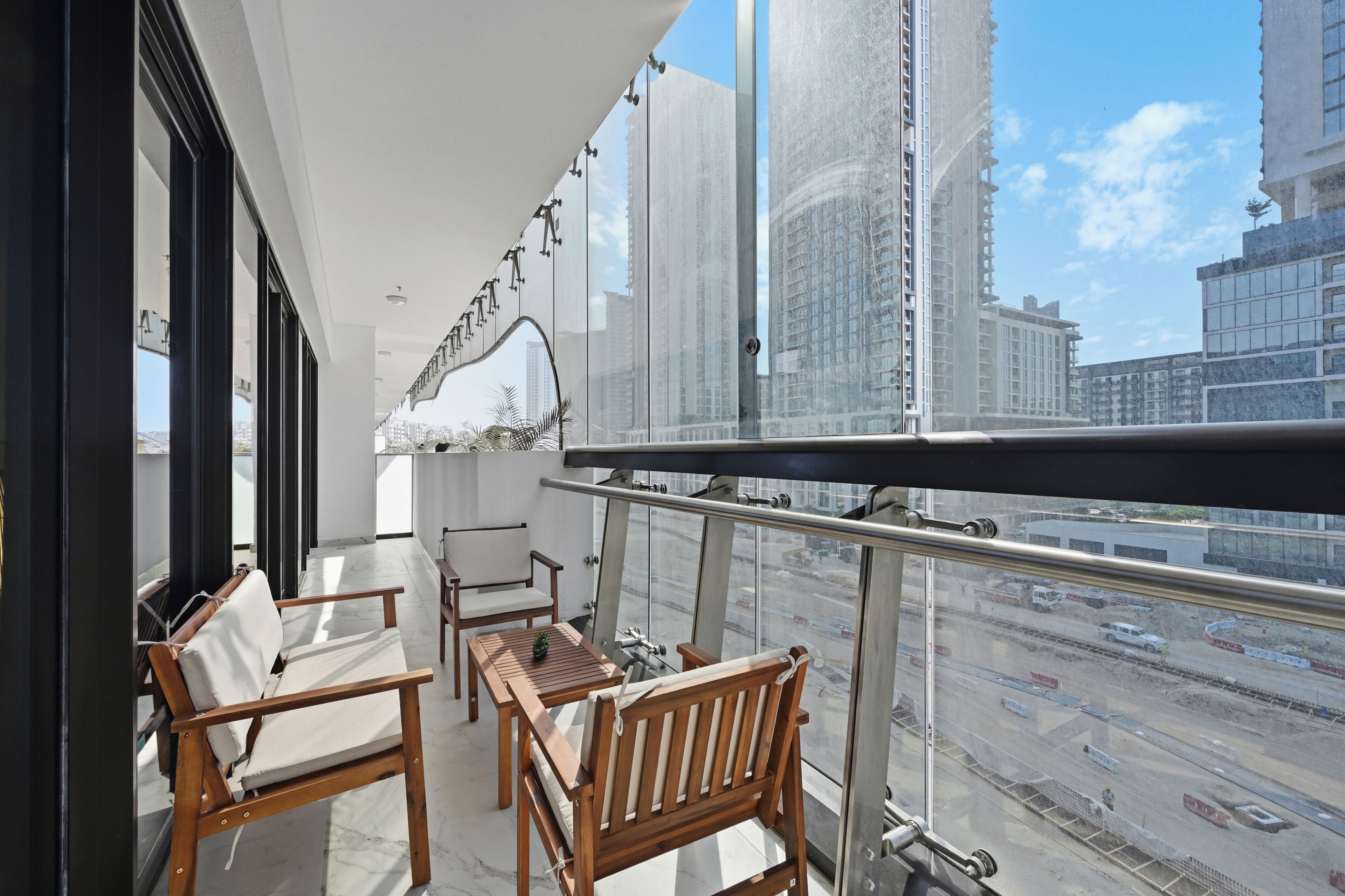 A balcony with a view of a cityscape, including tall buildings and a busy road.