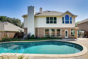 Ein zweistöckiges Haus mit Swimmingpool im Garten.