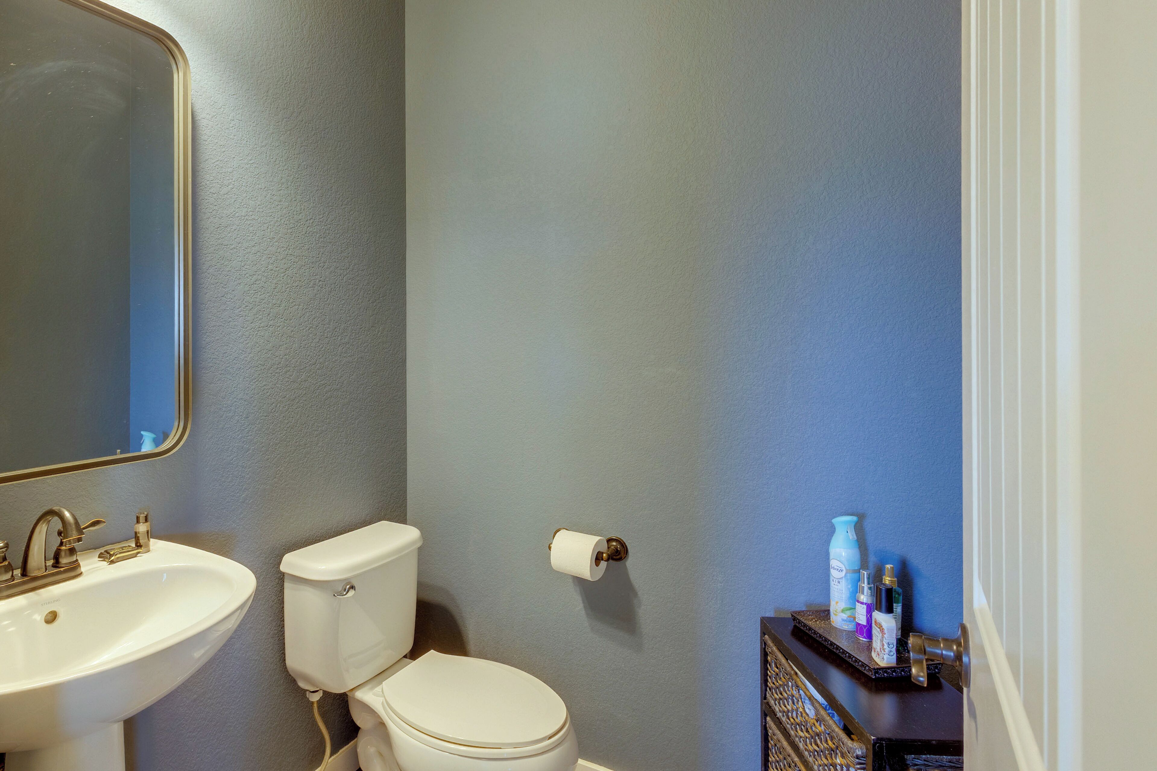 Une salle de bain avec un lavabo, des toilettes et un miroir.