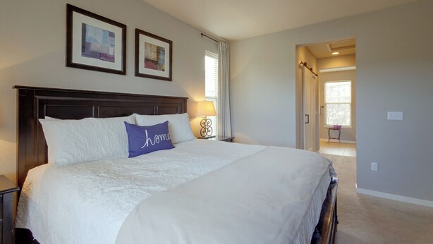 A bedroom with a large bed, a ceiling fan, framed pictures on the wall, and a window with curtains. - Hot Tub, Mtn Views, Resort Perks! Granby Getaway (Granby)
