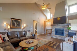 A spacious living room with a leather sofa, a fireplace, and a television. - Hot Tub, Mtn Views, Resort Perks! Granby Getaway (Granby)