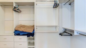 A walk-in closet with open shelves, hanging space, and a bed with a blanket. - 5 Mi to Estrella Mtn Park! Home w/ Outdoor Oasis (Goodyear)