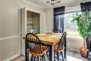 A dining area with a wooden table and chairs, a 'Welcome' sign, and a potted plant. - 5 Mi to Dtwn Greenville! Getaway w/ Deck & Yard (Greenville)