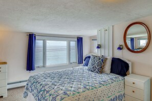A bedroom with a bed, a dresser, a mirror, and a window with curtains. - Ocean & Marsh Views! Wells Condo w/ Outdoor Space (Wells)