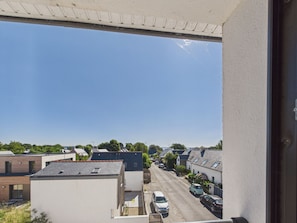 A residential street with houses, cars parked along the side, and a clear blue sky. - Apartment for 4 - Shared Garden - Terrace - WiFi (Fouesnant)