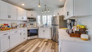A modern kitchen with white cabinets, stainless steel appliances, and a wooden floor. - 5 Mi to Fort Myers Beach! Home w/ Resort Perks (Fort Myers)