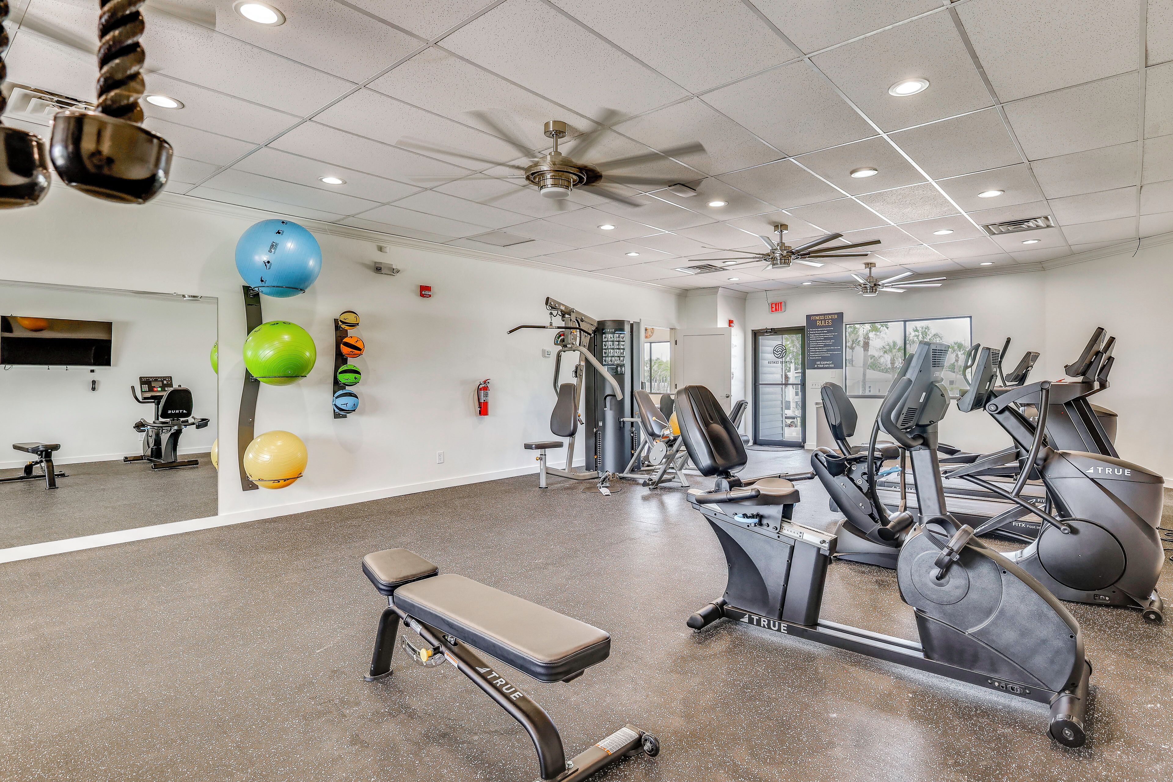 A gym with exercise equipment, a bench, and a ceiling fan.