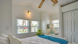 A bedroom with a bed, two windows, a ceiling fan, a nightstand, and a door. - 5 Mi to Fort Myers Beach! Home w/ Resort Perks (Fort Myers)