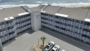 A multi-story hotel with a beach view, named 'Dunescape Villas 3,' featuring balconies, parking, and a central building with signage. - Dunescape 132-Ocean Front Condo w/Pool (Atlantic Beach)