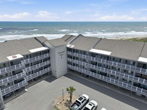 A multi-story hotel with a beach view, named 'Dunescape Villas 3,' featuring balconies, parking, and a central building with signage. - Dunescape 132-Ocean Front Condo w/Pool (Atlantic Beach)
