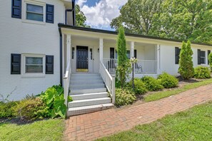 A two-story house with a front porch, a set of stairs leading to the entrance, and a brick pathway. - Lake Norman Launchpad: Home Near Dtwn Mooresville (Mooresville)