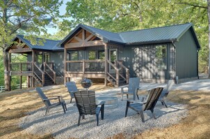 Una cabaña con terraza, mobiliario exterior y una chimenea.