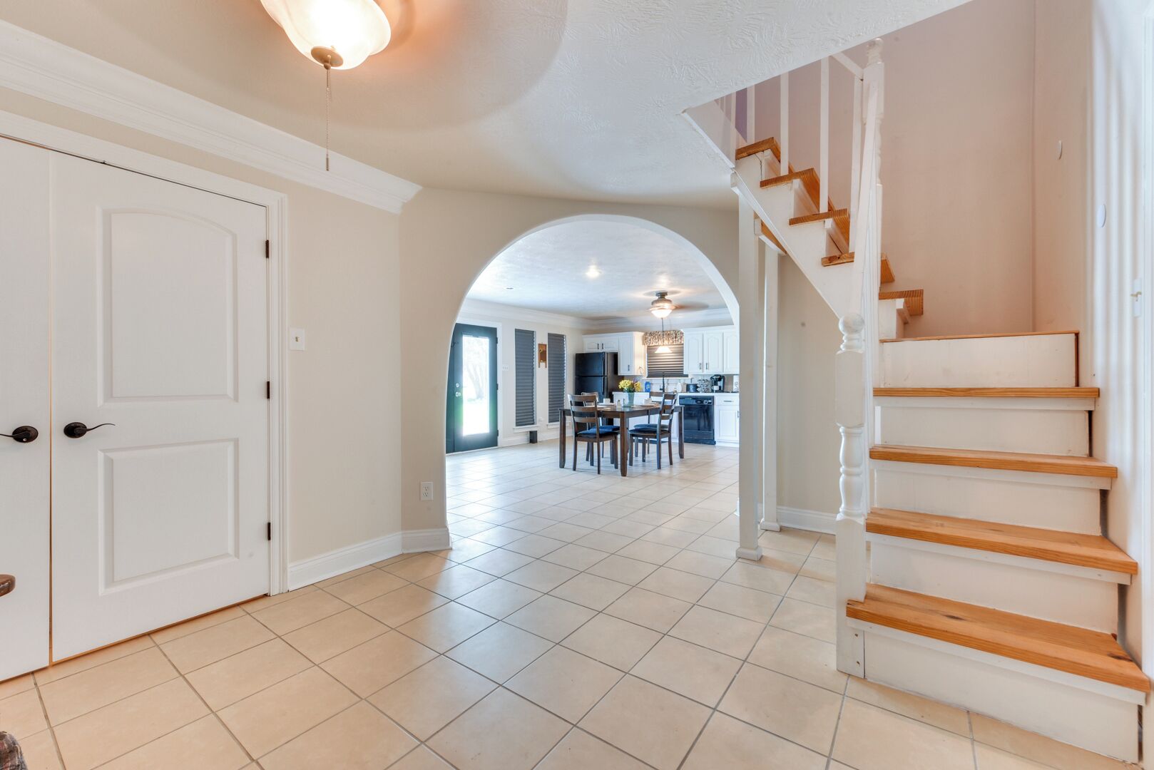 A spacious hallway with a staircase leading to a dining area.