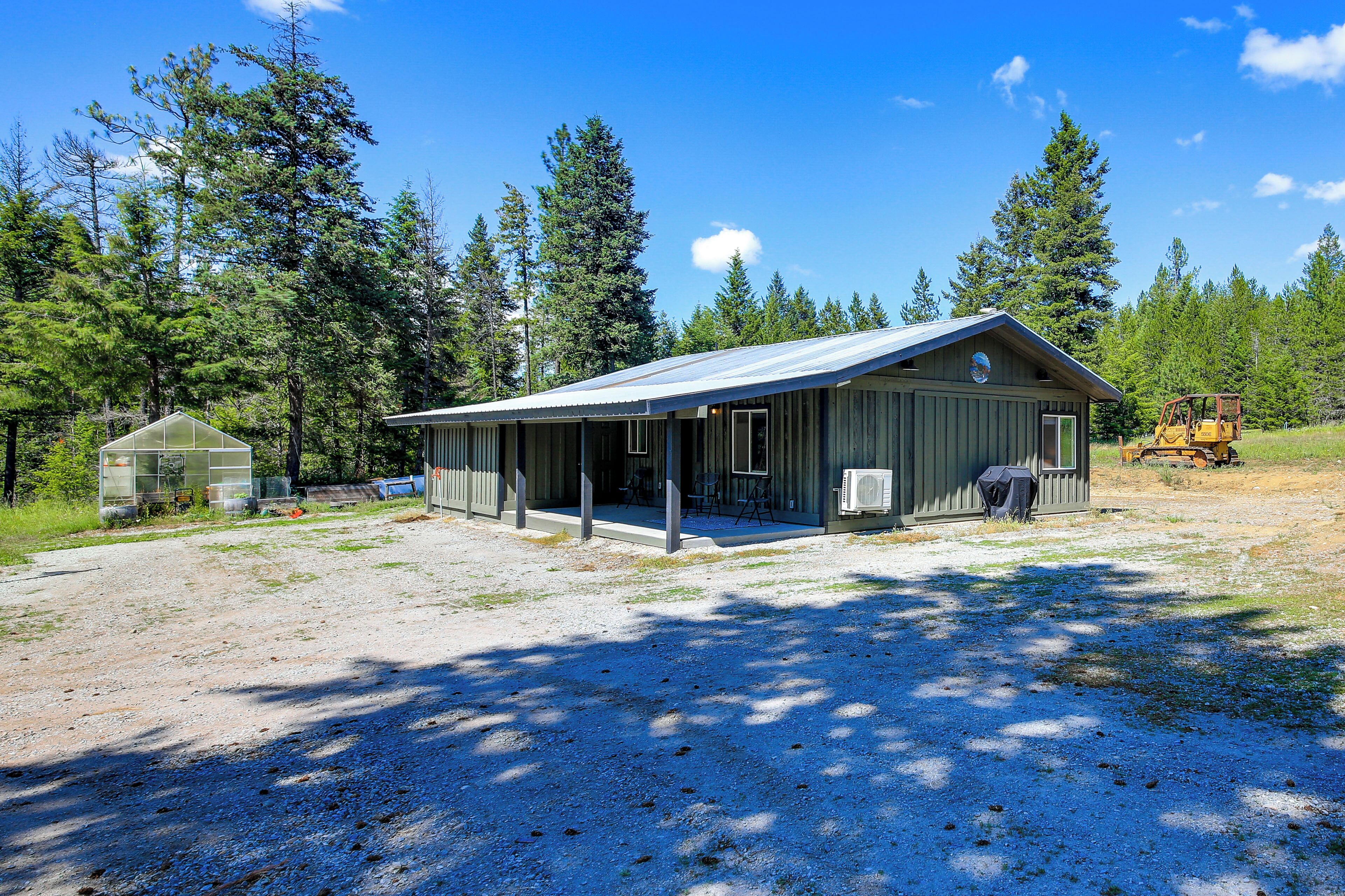 A single-story building with a covered porch, a small attached shed, and a clear sky.