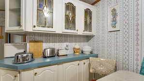 A kitchen with white cabinets, a blue countertop, and a vintage toaster.