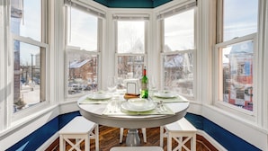 Un rincón comedor con ventana saliente que da a vistas de la ciudad.