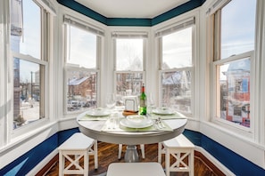 A corner dining area with a bay window overlooking a cityscape. - Walk to Downtown! Central 2-apt Combo in Pottstown (Pottstown)
