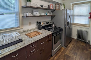 A kitchen with a granite countertop, stainless steel appliances, wooden cabinets, and a sign that says "COFFEE TIME". - Walk to Downtown! Central 2-apt Combo in Pottstown (Pottstown)