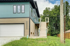 A two-story house with a garage, a balcony, and a wooden fence in the background. - Close to Ohio River: 6BR Jeffersonville Home (Jeffersonville)
