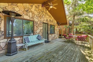 A stone exterior with a covered deck, outdoor seating, and a patio area. - Lake-view Deck! Lake of the Ozarks Home in Edwards (Edwards)