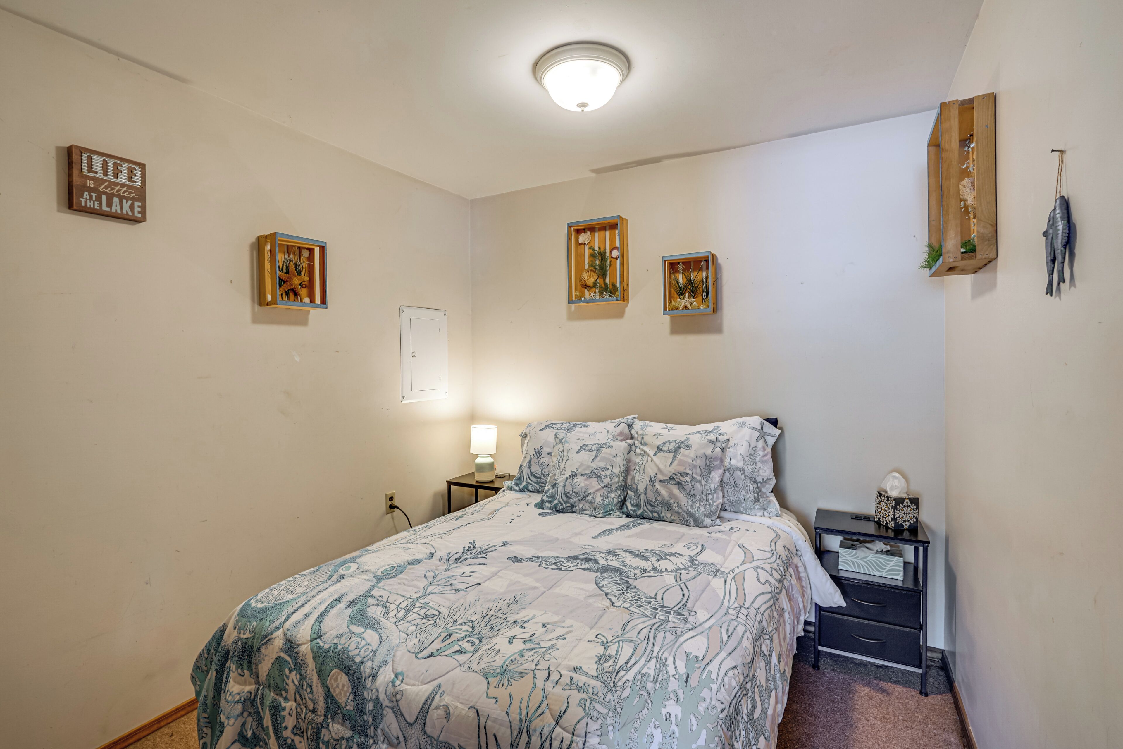 Une chambre à coucher comprenant un lit, des tables de chevet, des décorations murales et un luminaire au plafond.