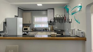Une cuisine moderne dotée d’un plan de travail en bois, d’un réfrigérateur, d’un four à micro-ondes et d’un grille-pain.