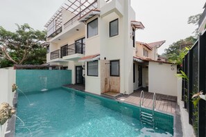 A two-story building with a swimming pool in the foreground. - Staymaster Abira-3BR Pvt Pool Villa (Assagao)