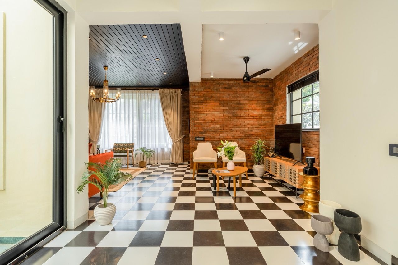 A hotel lobby with a checkered floor, a brick wall, and a ceiling fan.