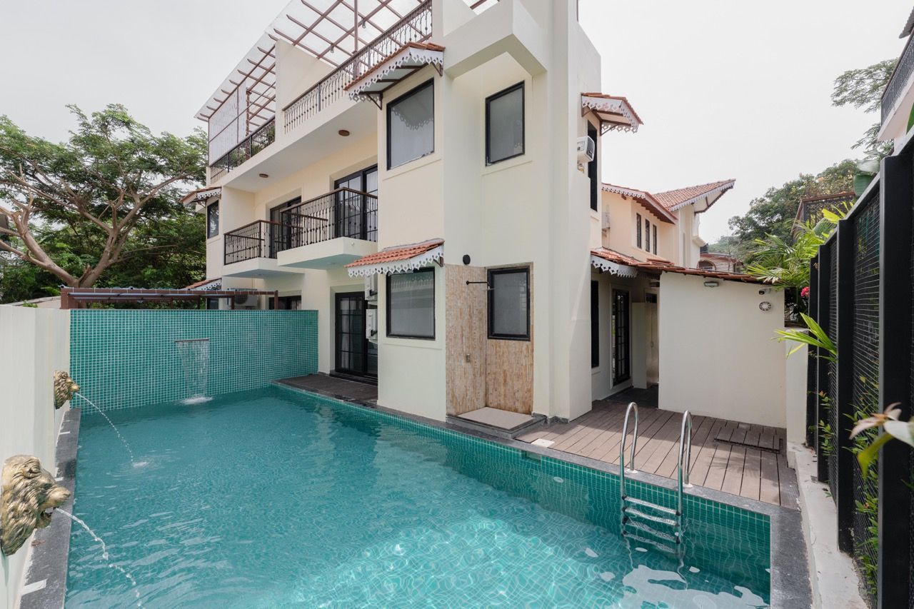 A two-story building with a swimming pool in front.