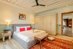 A bedroom with a bed, bedside tables, a ceiling fan, a wardrobe, and a patterned rug. - Staymaster Abira-3BR Pvt Pool Villa (Assagao)