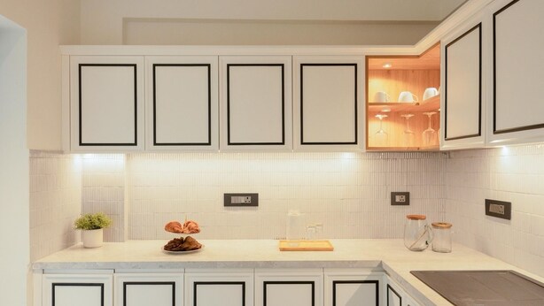 A modern kitchen with white cabinetry, a countertop with a cutting board, and a sink. - Staymaster Abira-3BR Pvt Pool Villa (Assagao)