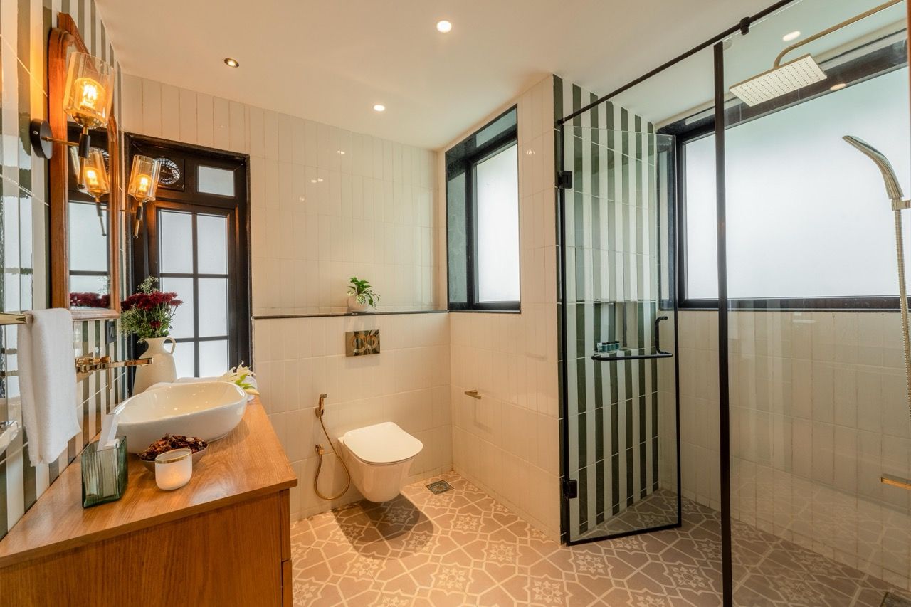 Ein modernes Badezimmer mit einer Duschkabine aus Glas, einem Holzwaschtisch mit Waschbecken und einer Toilette.