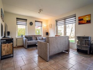 Ein Wohnzimmer mit einer Couch, einem Fernseher und einem Kamin.