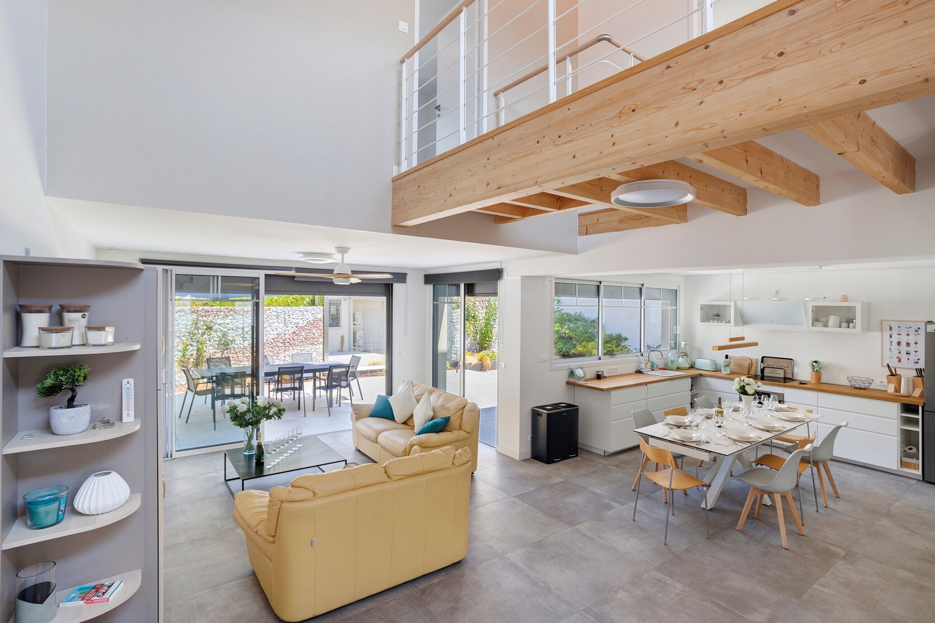 A spacious living area with a sofa, dining table, and kitchen area.