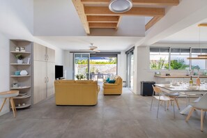 A modern interior with a sofa, dining table, and kitchen area.
