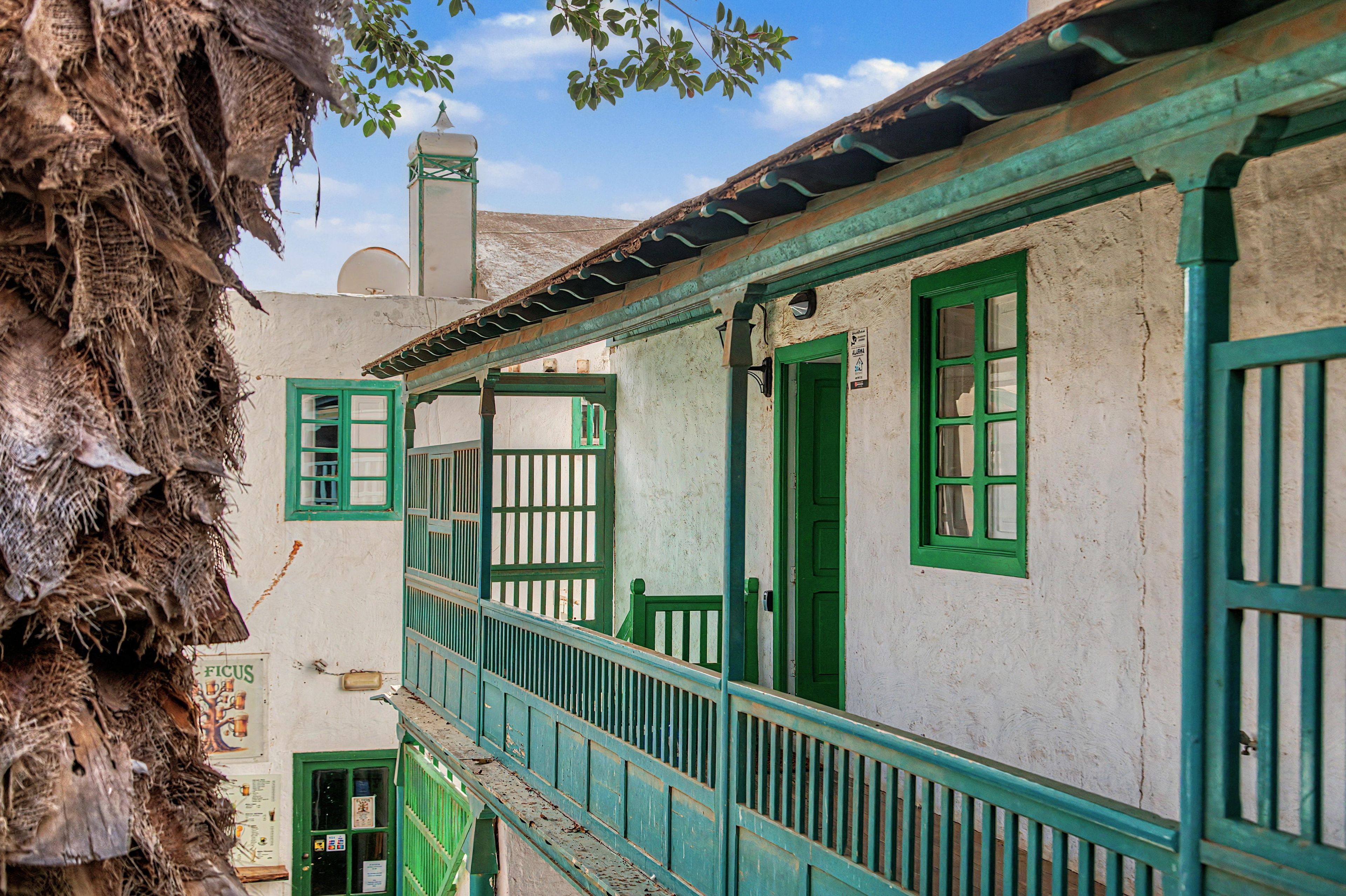 A traditional building with a balcony, a door, and a window.