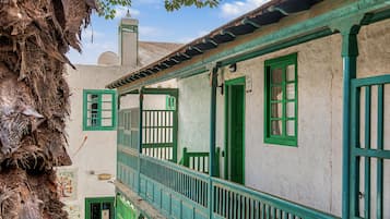 A traditional building with a balcony, a door, and a window.