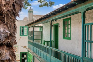 A traditional building with a balcony, a door, and a window.