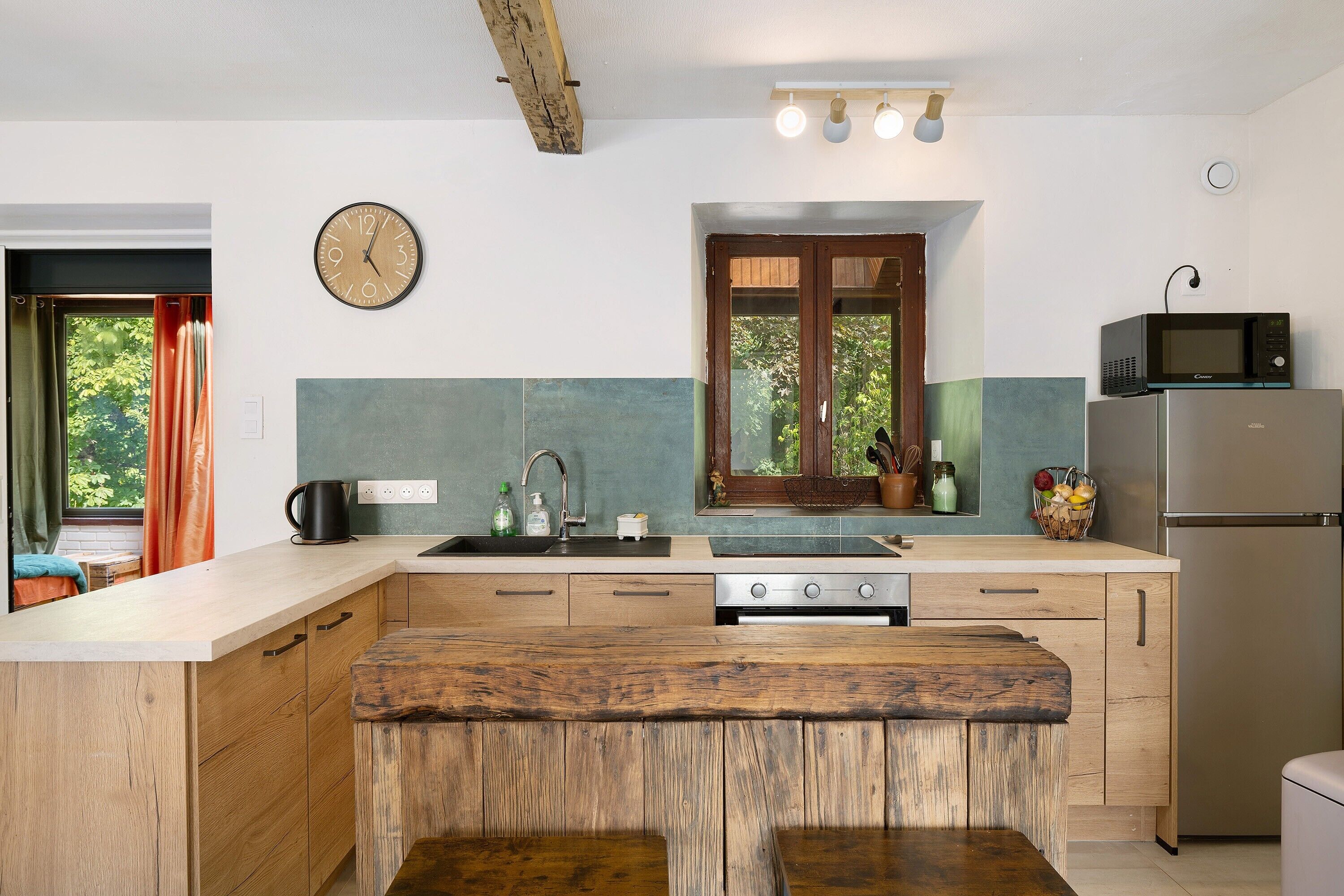 Een moderne keuken met een centraal eiland, een inbouwoven en een magnetron.