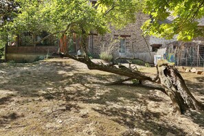 A rustic stone building with a large tree in the foreground. - Holiday Home “Sana” with Garden at the Gates of Brocéliande (Paimpont)