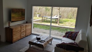Ein Wohnzimmer mit einer Schiebetür, die auf eine Terrasse im Freien führt.