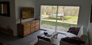 A living room with a sliding glass door leading to an outdoor patio area. - Garden-Level Apartment (Sainte-Maxime)