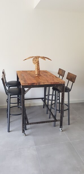 A dining table with a unique sculpture centerpiece, surrounded by four chairs. - Garden-Level Apartment (Sainte-Maxime)